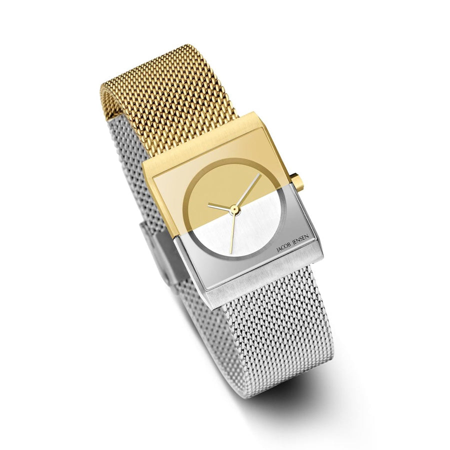 Ervaar de moderne elegantie van Jacob Jensens 526 horloge, met een rechthoekige wijzerplaat met gouden en zilveren helften en een naadloze meshband. Dit minimalistische Quartz-stuk heeft eenvoudige uur- en minutenwijzers op het saffierkristallen display, wat tijdloze verfijning uitstraalt.