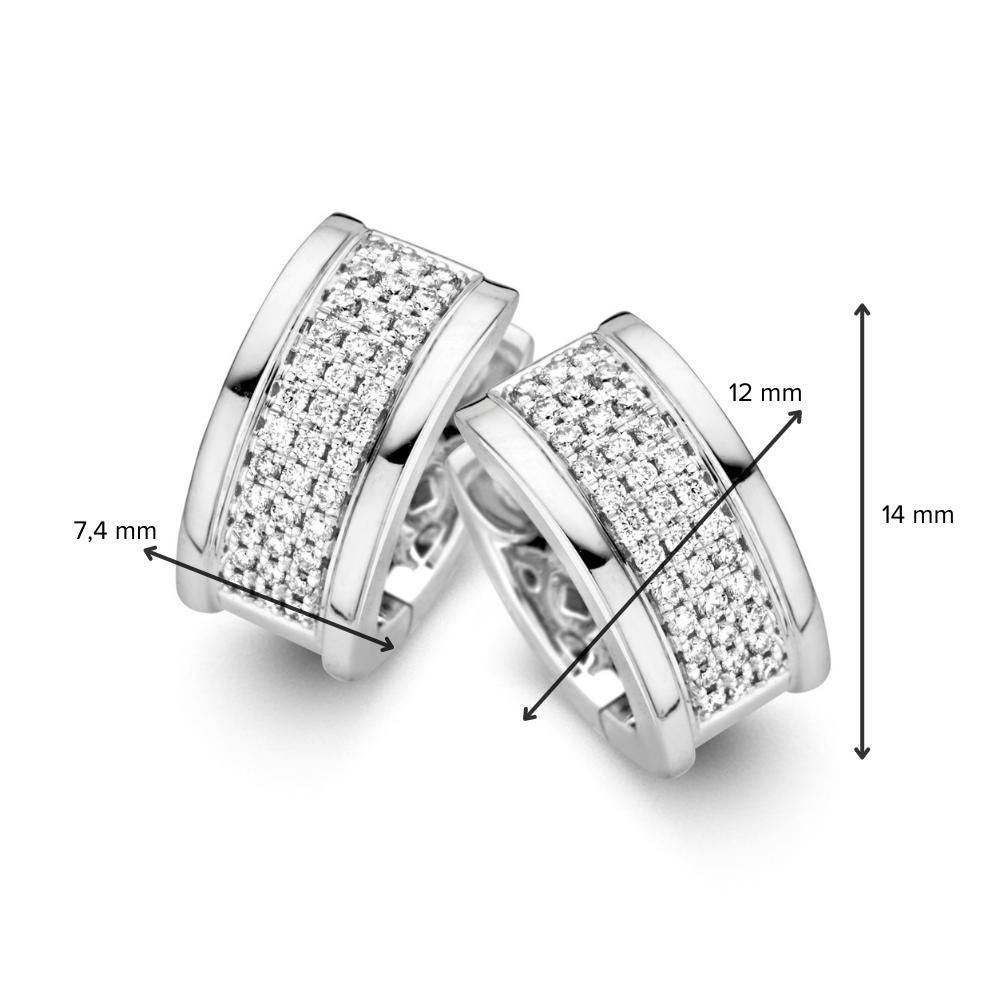 De Elegante witgouden oorringen met briljantdiamanten in pavézetting van Excellent Jewelry zijn 14 karaat huggie oorringen van 14 mm hoog, 12 mm breed en 7,4 mm diep, bezet met kleine briljant geslepen diamanten.