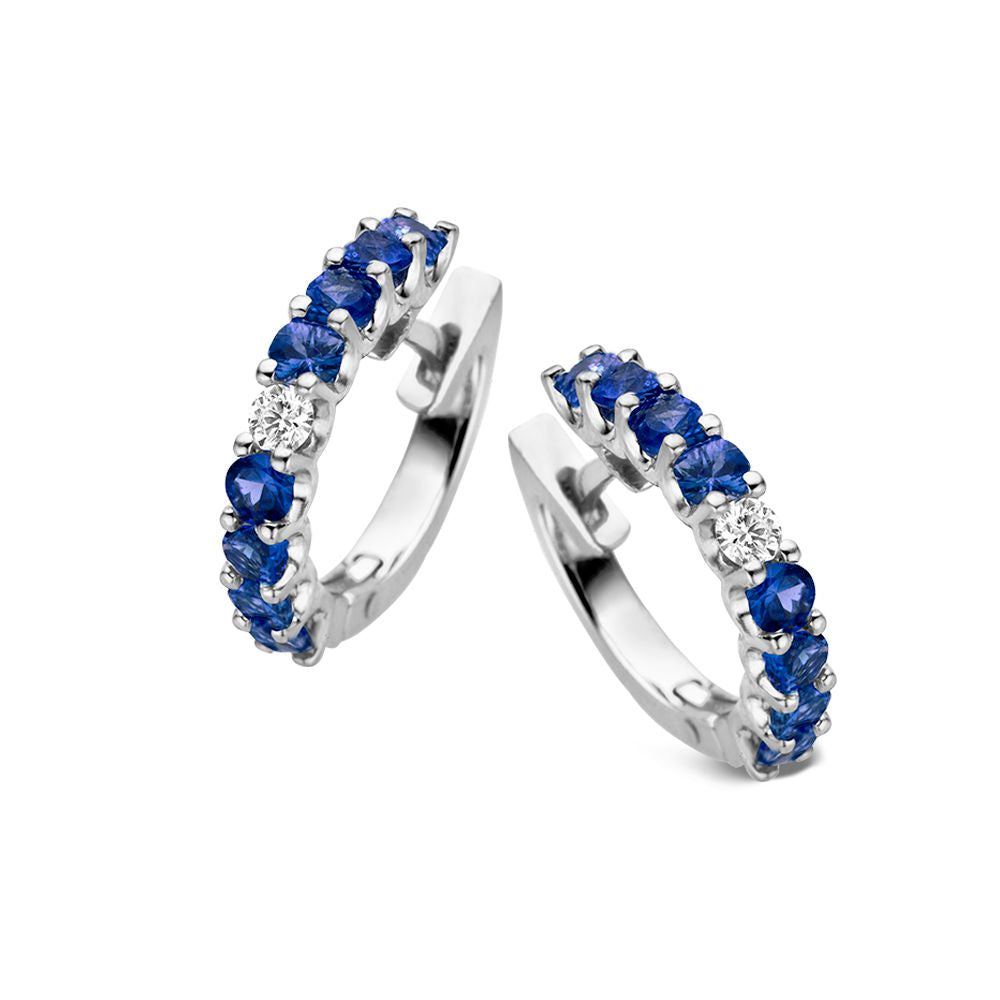 Witgouden oorringen met blauwe saffieren en diamanten, in een halve cirkelvormige setting.