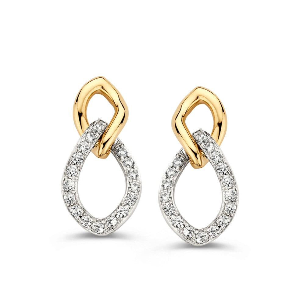 Bicolor oorstekers van wit- en geelgoud met een druppelvorm en zirkonia's in de onderrand.
