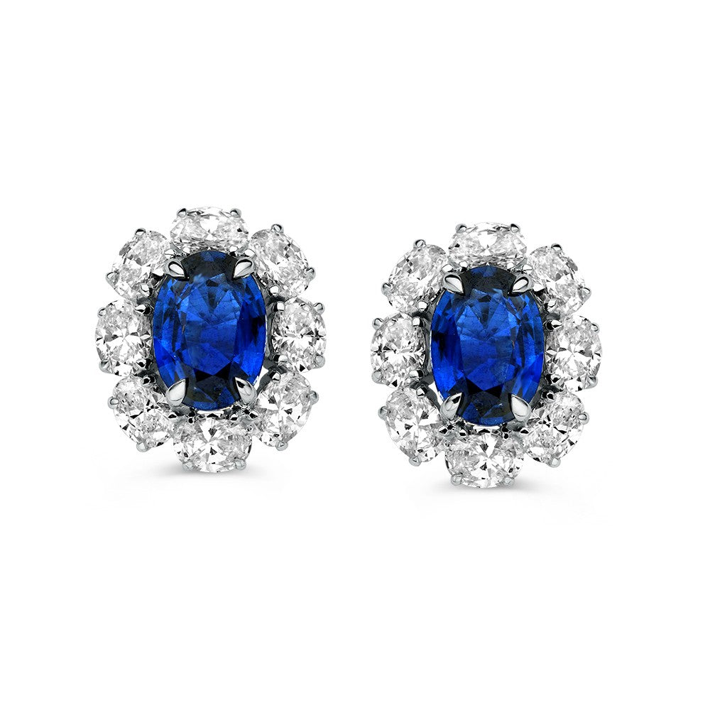 Bicolor oorstekers met een centrale saffier omringd door briljant geslepen diamanten.