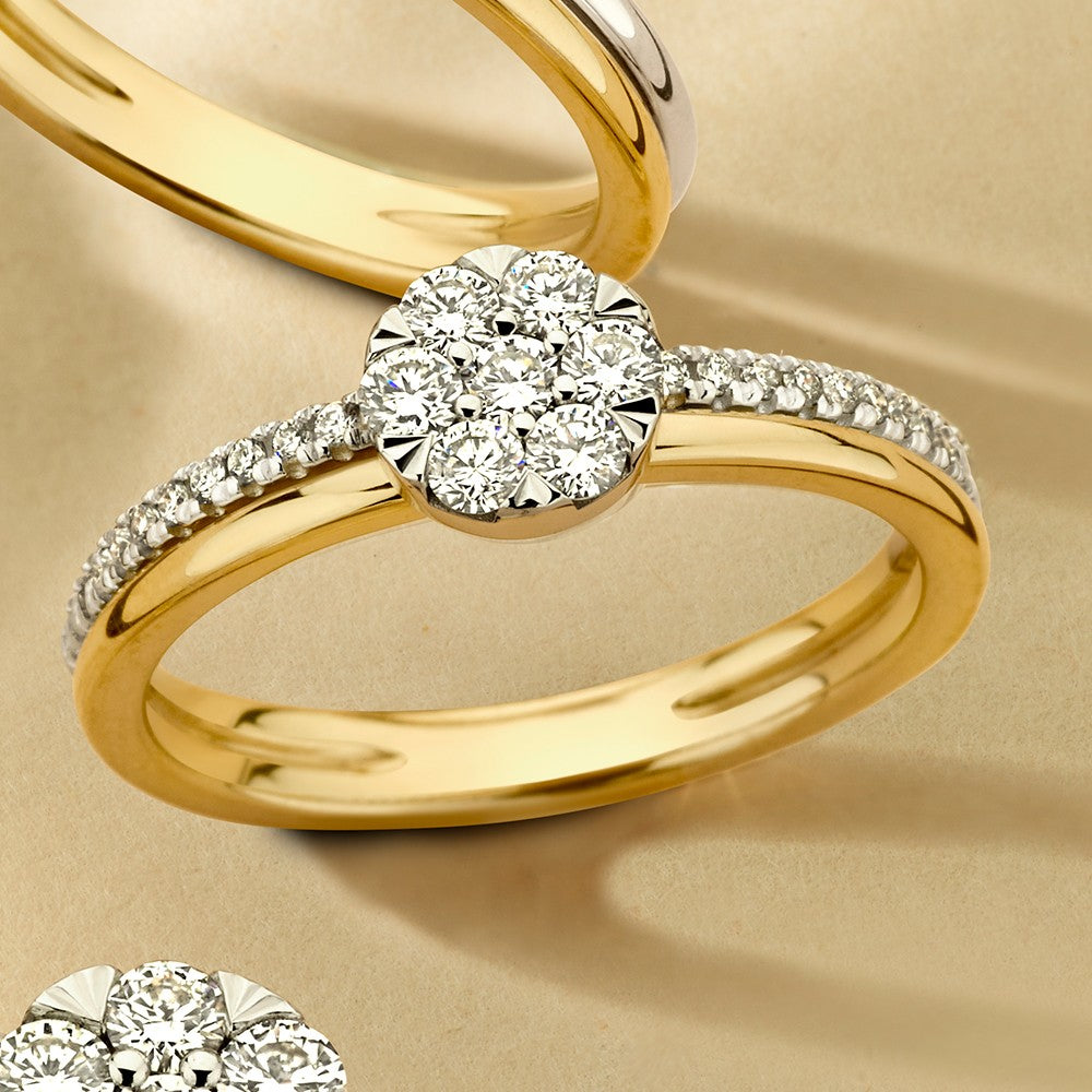 Bicolor ring van geel en wit goud met een briljant van 0,36 crt en een pavé van kleinere steentjes aan de zijkanten.