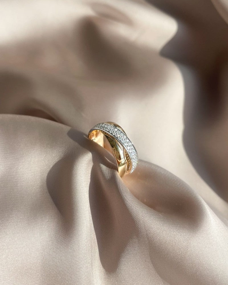 De Luxe Crossover Ring met 0,37ct Briljant Diamant van Excellent Jewelry wordt getoond op een zacht gedrapeerde, lichtbeige satijnen stof.