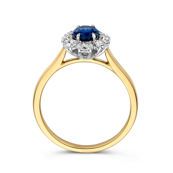 Een Ring bicolor briljant + saffier van Excellent Jewelry, Lady Di stijl: centrale blauwe saffier omringd door fonkelende diamanten in een elegante witgouden zetting.