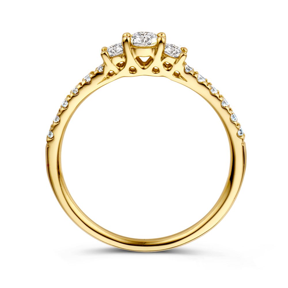 De Geelgouden Driesteens Ring met Extra Diamanten in de Scheen voor Maximale Schittering van Excellent Jewelry is een 14 karaat geelgouden ring met centrale ronde diamant, twee zijdiamanten en extra diamanten langs de band.