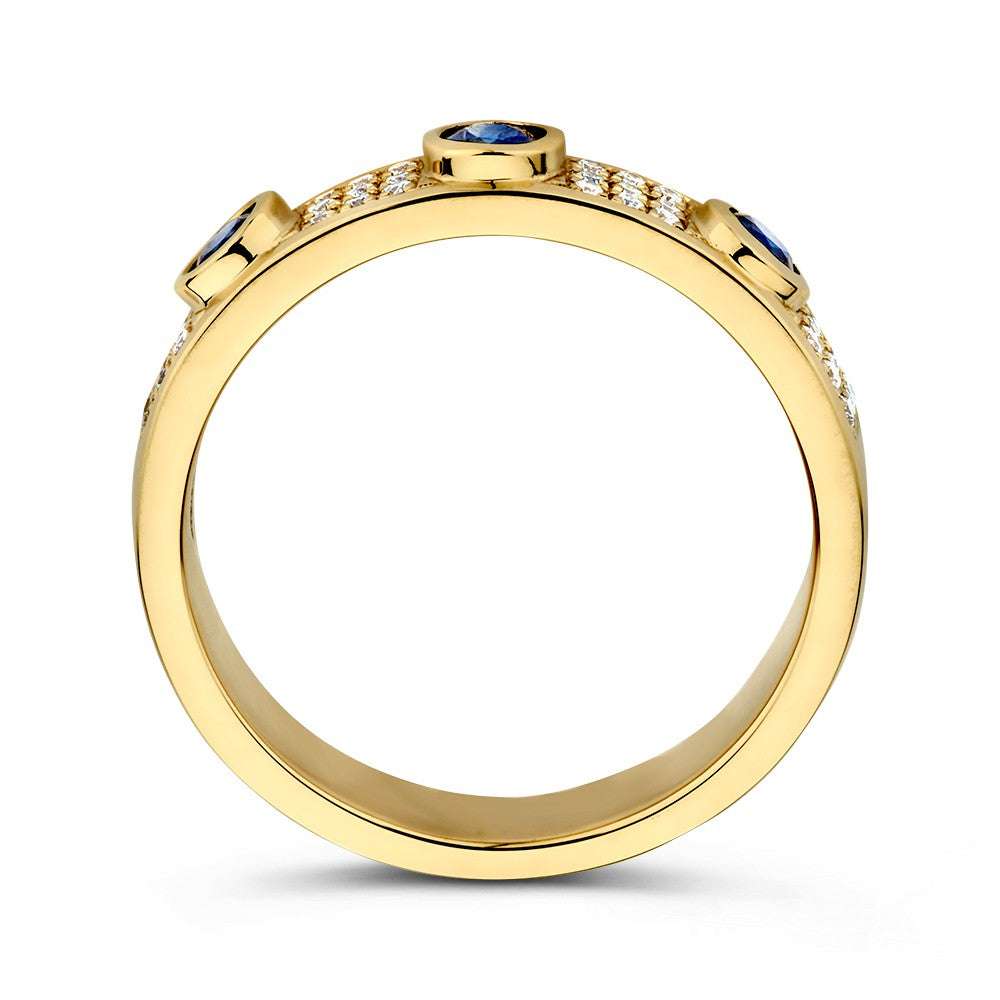 De Excellent Jewelry Geelgouden Ring met Diamant en 3 Blauwe Saffieren (14 karaat, 0.38 crt saffier, 0.17 crt diamant) is afgebeeld vanaf de zijkant met drie ronde saffieren bovenop en diamant accenten langs de band tegen een witte achtergrond.