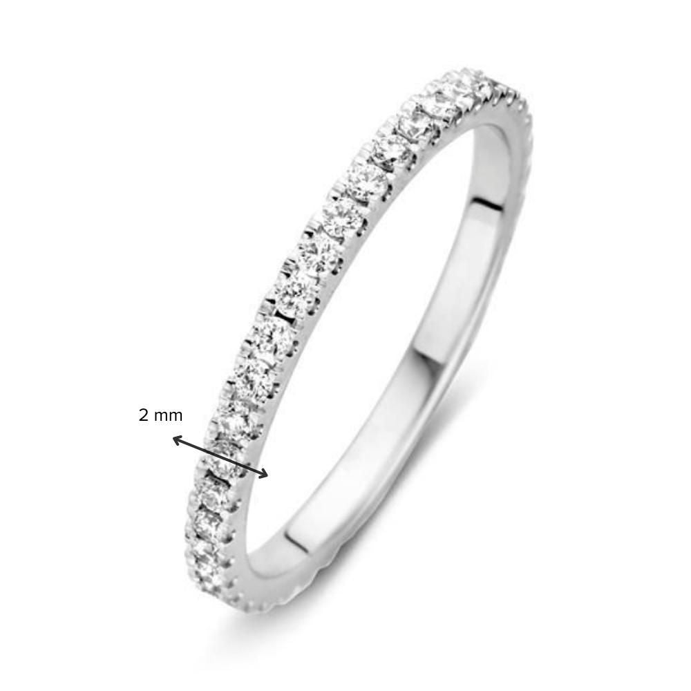 De Stunning White Gold Eternity Ring van Excellent Jewelry heeft 0,50 karaat diamanten gezet rond een slanke 2 mm 14-karaats band, afgebeeld tegen een effen witte achtergrond. Een pijl geeft de breedte van de ring aan.