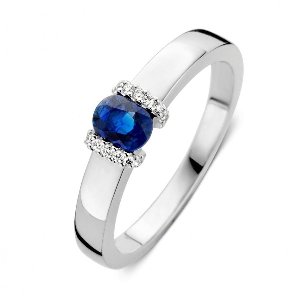 Witgouden ring met een ovale blauwe saffier en drie kleine diamanten aan elke zijde.