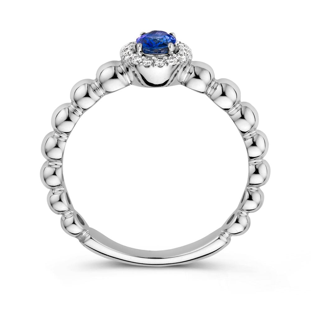 De 14 Karaat Witgouden Rijring met Blauwe Saffier en 0,14 Caraat Diamanten van Excellent Jewelry is afgebeeld op een witte achtergrond, met een ronde blauwe saffier in het midden en omringd door schitterende diamanten.
