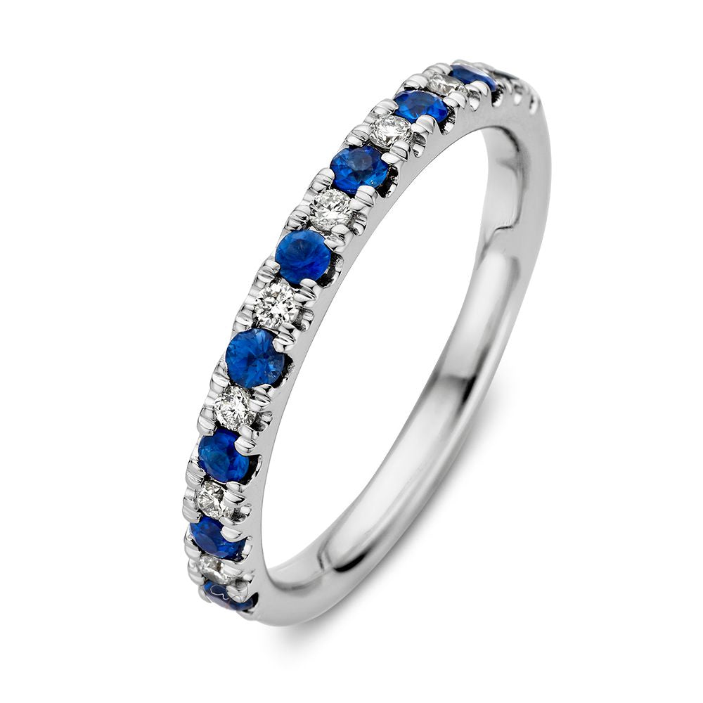 De 14 Karaat Witgouden Rijring met Blauwe Saffier en 0,14 Caraat Diamanten van Excellent Jewelry schittert met afwisselend saffieren en diamanten op de band.