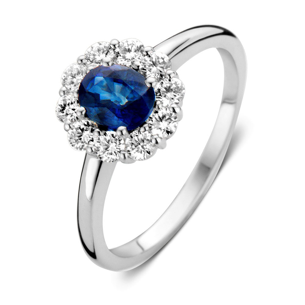 Witgouden ring met een ronde blauwe saffier omringd door een cirkel van diamanten.