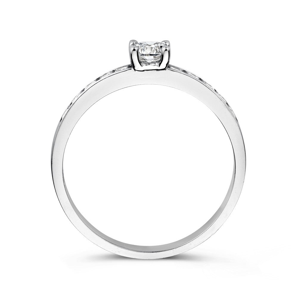 Een close-up van de Witgouden Damesring met Zirkonia's - Subtiele Elegantie van Excellent Jewelry, met een delicate zirkonia met tandjes, tegen een witte achtergrond.