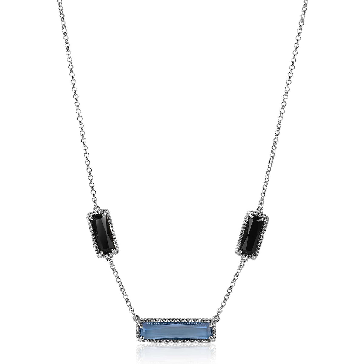 Zilveren ketting met een blauwe en twee zwarte edelstenen in een moderne, minimalistische opstelling.