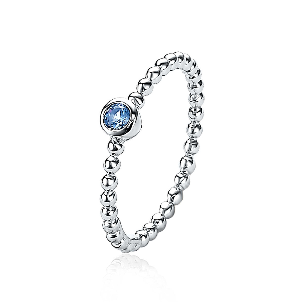 Zilveren ring met bolletjesdesign en een blauwe steen in een zetting.