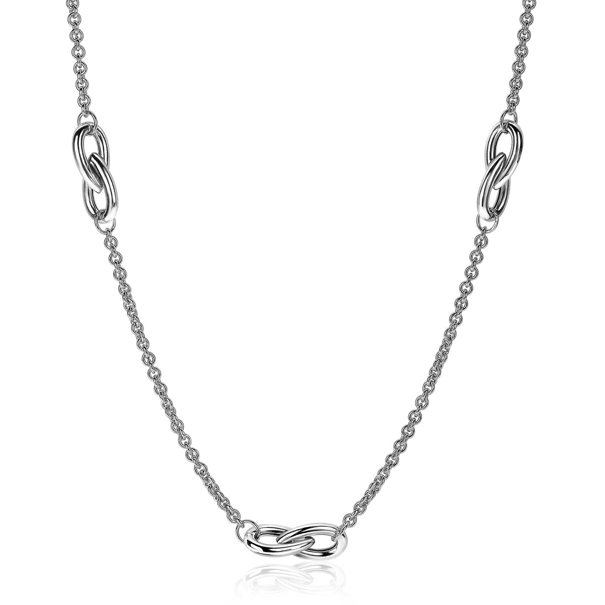 Zilveren ketting met een schakelpunt in een gedraaide vorm en een fijne bolletjesketting.