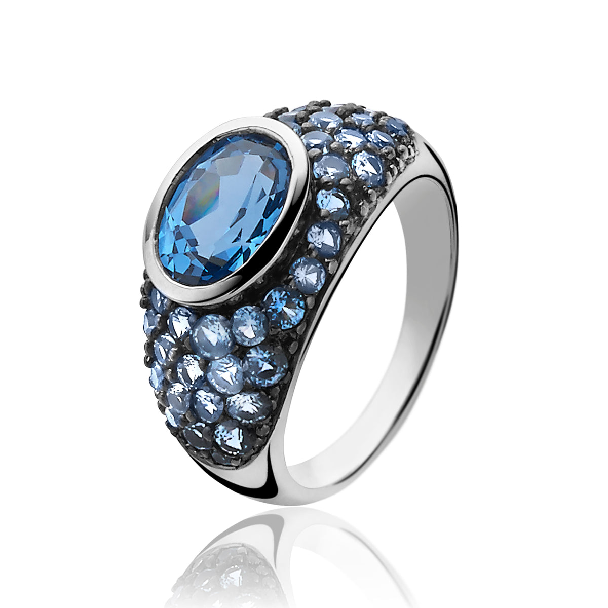 Zilveren ring met een grote blauwe steen en kleine blauwe zirkonia's in een ronde setting.
