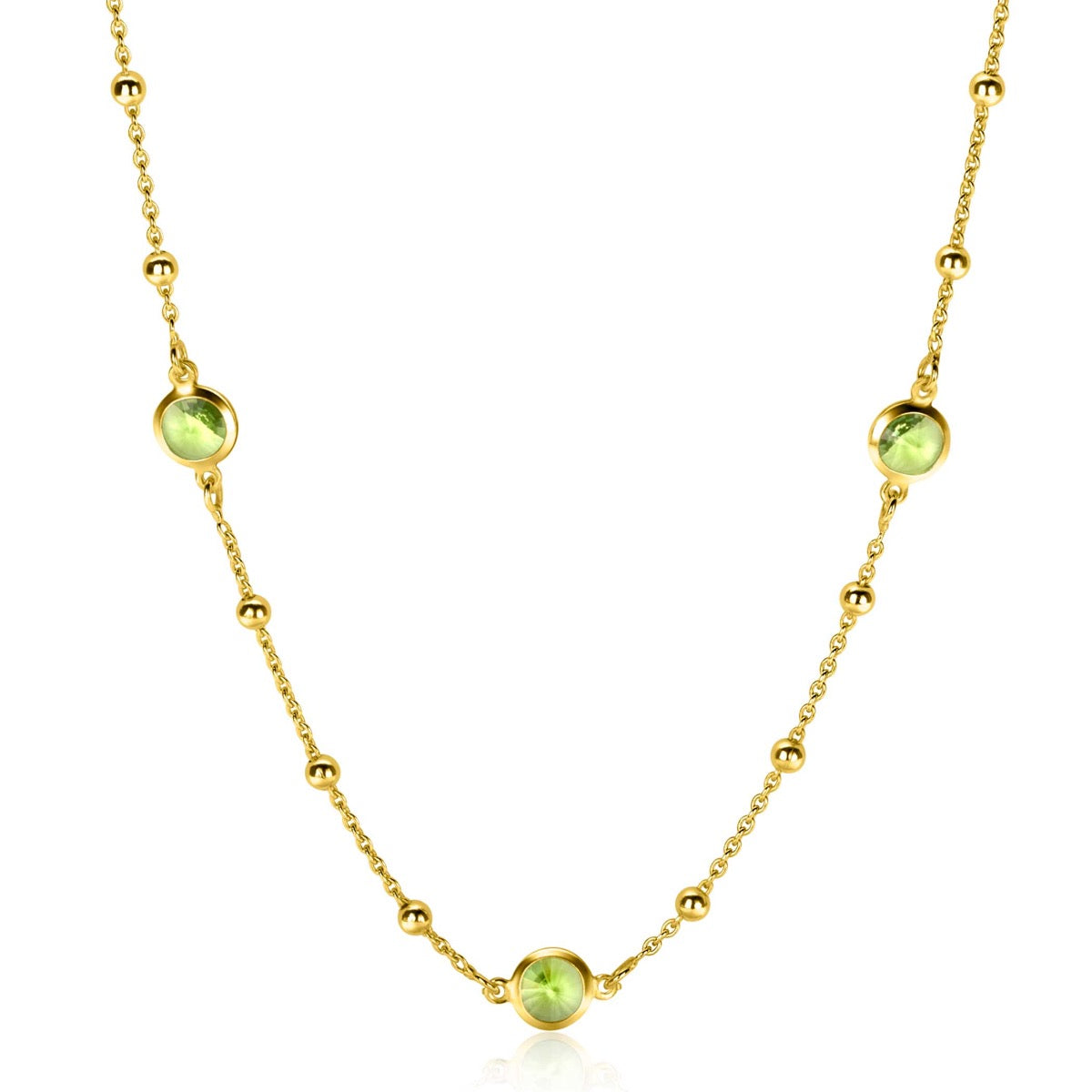 Gouden ketting met groene stenen en bolletjes in een speels ontwerp.