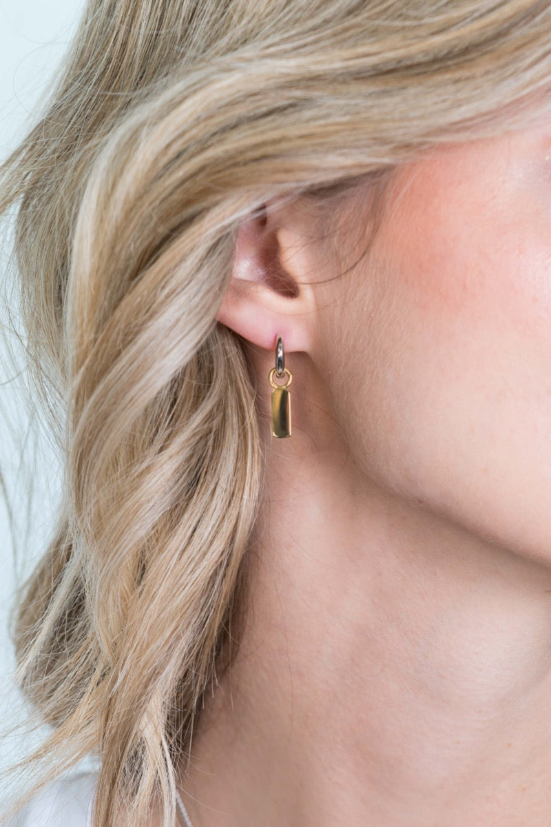 Gouden, vergulde oorbellen met een hangend, gestileerd ontwerp en een subtiele ringdetail.